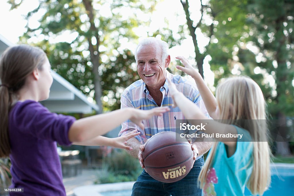 D Homme jouant au basket-ball avec granddaughters - Photo de Jouer libre de droits