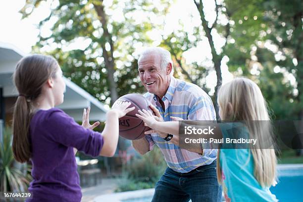 Anziani Uomo Giocando A Basket Con Granddaughters - Fotografie stock e altre immagini di Tendere la mano - Tendere la mano, 65-69 anni, 8-9 anni