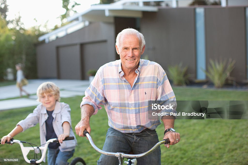 Homme et son petit-fils d'équitation vélos extérieur - Photo de 10-11 ans libre de droits