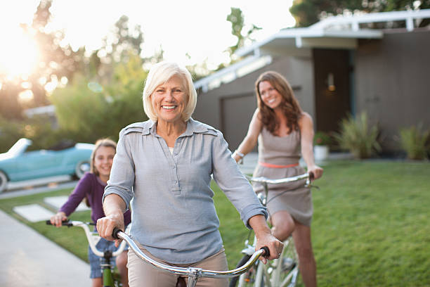 tres generaciones de mujeres montar bicicletas - grandmother standing senior women senior adult fotografías e imágenes de stock