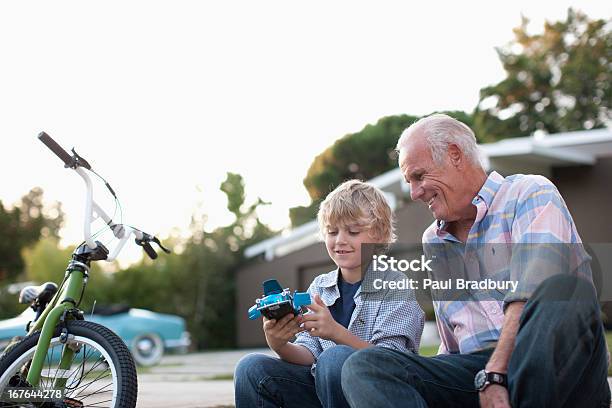 Photo libre de droit de Monsieur Plus Âgé Assis Ensemble Et Petitfils banque d'images et plus d'images libres de droit de Grand-père - Grand-père, Enfant, Petit-fils