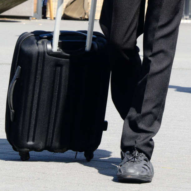 istock Black suitcase with black trousers 1676444400