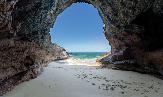 Cave Cueva de Playa de los Ojos at the southern tip of Fuerteventura - panoramic view from the cave to the sea at low tide