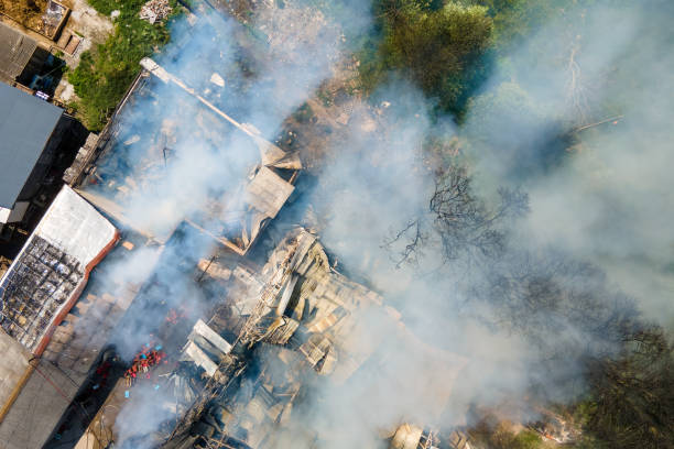 vista aérea do prédio em chamas com telhado desabado e fumaça escura. - distress rocket - fotografias e filmes do acervo