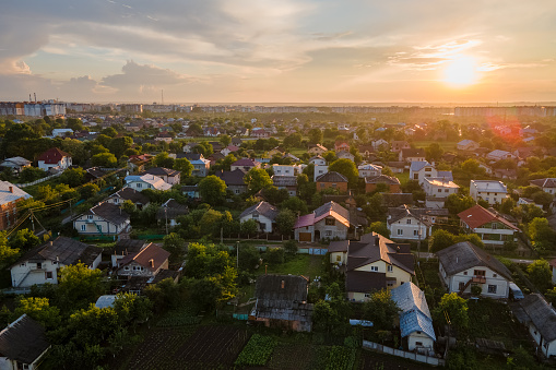 Aerial view of residential houses in suburban rural area at sunset.