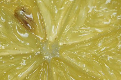 Juicy yellow lemon slice, closeup of citrus fruit pulp