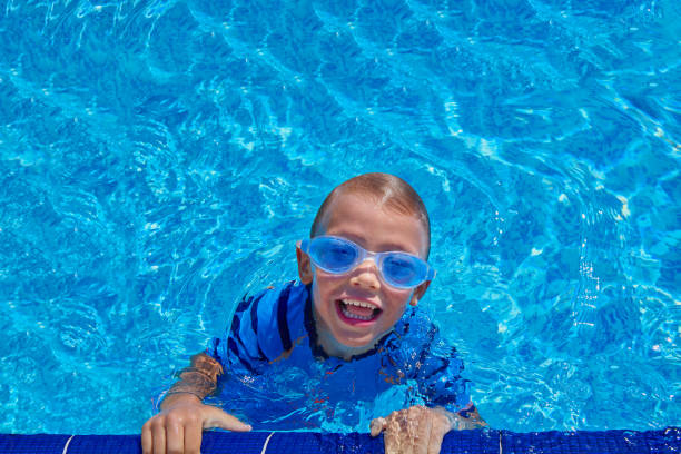 enfant de race blanche s’amusant dans la piscine avec des lunettes de natation - child nautical vessel summer swimming goggles photos et images de collection
