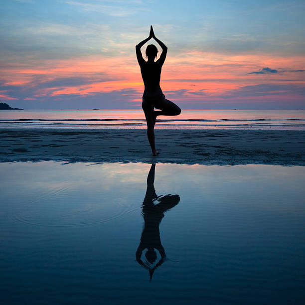 istock Young woman practicing yoga at sunset on the coast 167647906