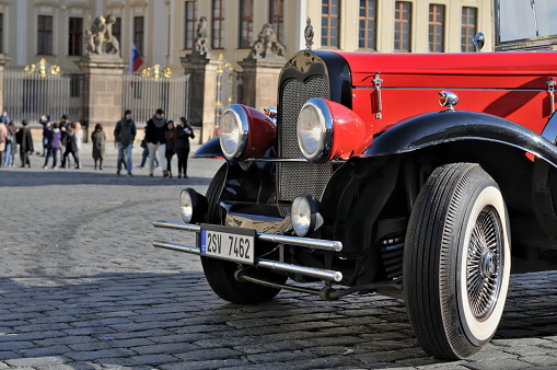 Classic car for sightseeing tours around Prague historical city center in Czech republic. Car is parked in front of Prague castle.