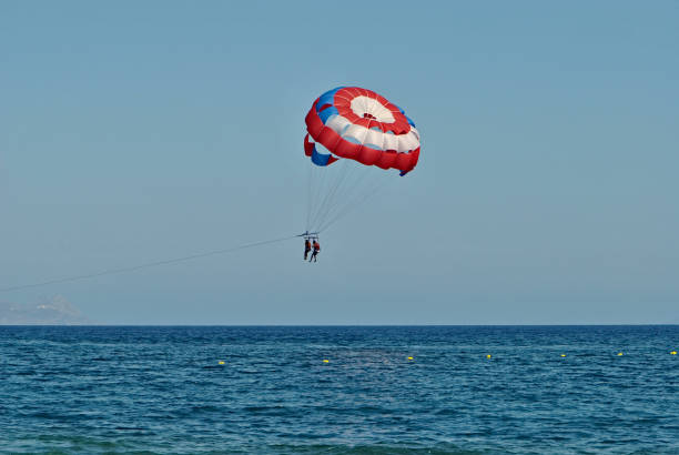 istock Pair is enjoying parasailing on summer vacation on Santorini Island. 1676498835
