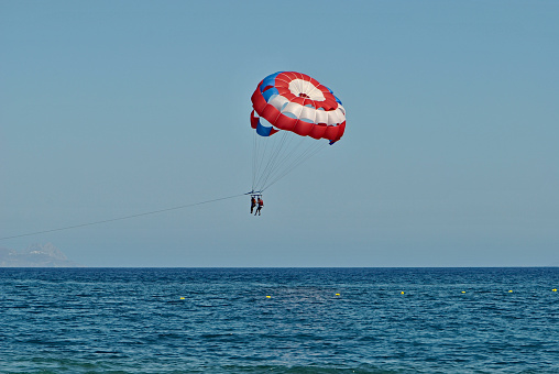 With the vast sky behind her, the young woman's parachute landing captures the beautiful transition from air to earth