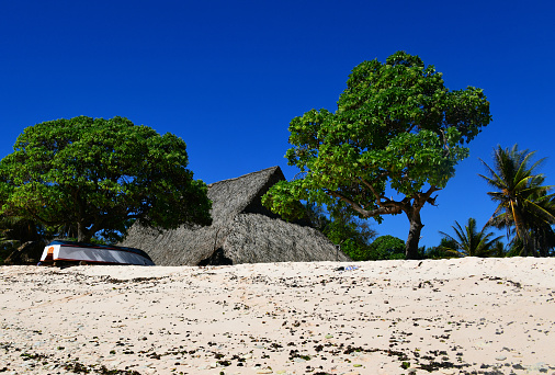 Temwaiku, South Tarawa Atoll, Gilbert Island, Kiribati: Maneaba or Mwaneaba is the name of a traditional meeting house in Kiribati (maneapa in Tuvalu), the building has both sacred and secular functions. It is understood as the common house of the community. Sometimes there are several of these houses for the different clans. In addition to being a meeting place to make important joint decisions for the community, it is also a celebration center, e.g. for dance and singing performances. A traditional maneaba is an imposing structure, the vernacular architecture employes slabs of coral supporting a huge roof formed from coconut trunks, held together with coconut string and thatched with pandanus leaves.