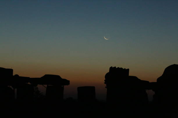 On the morning of a total eclipse, the moon and sun rise together over Carhenge in Alliance Nebraska