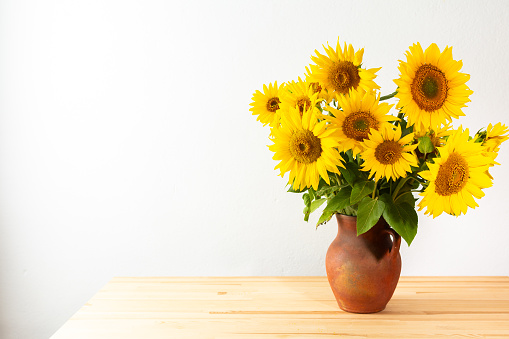 Summer rustic bouquet in a clay pot, bright juicy decorative sunflowers