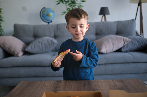 Little boy eats pizza