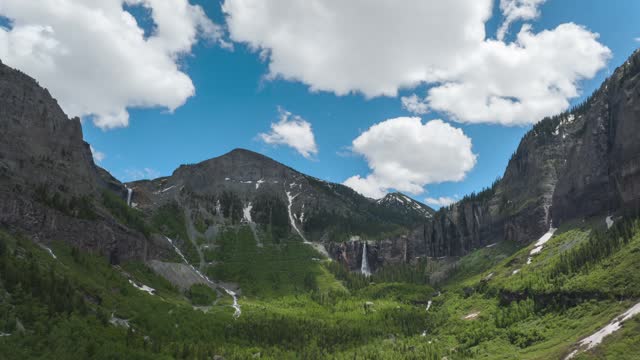 Clouds drifting over the Mountain Peaks, Telluride area of Colorado. Bridal Veil waterfall in the mountain. Timelapse