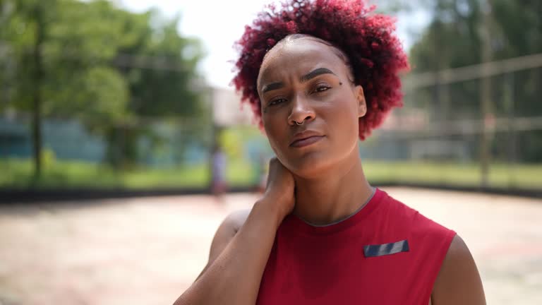 Portrait of a tired young woman in a sports court