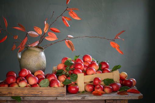 red apples on old wooden table on background green wall