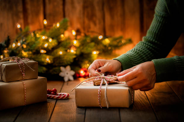 les mains de la femme arrangent un cadeau de noël - christmas paper christmas present christmas gift photos et images de collection