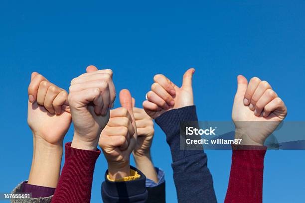 Thumbs Up Against Blue Sky Stock Photo - Download Image Now - Achievement, Group Of People, Hand Raised