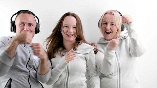 mom dad and daughter boxing with fists in frame with headphones family dancing fun pastime on white background blow close up be cheerful celebrate Listen to music dance sport beautiful people. leisure