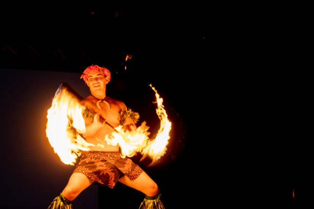 un danseur hawaïen virevolte une torche avec les mains. - fire dancer photos et images de collection