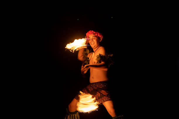 istock Hawaiian male dancer twirls torch with hands. 1676617860