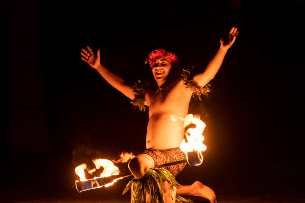 istock Hawaiian male dancer holding a torch with his leg. 1676618392