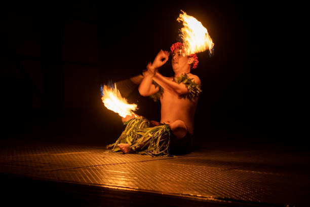 istock Hawaiian male dancer twirls torch with hands. 1676620514
