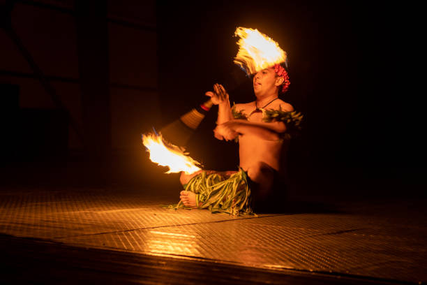 istock Hawaiian male dancer twirls torch with hands. 1676620516