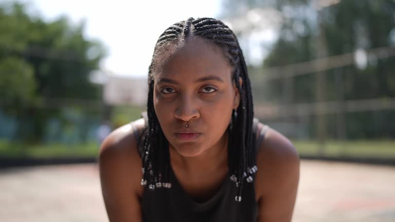 Portrait of a tired young woman in a sports court