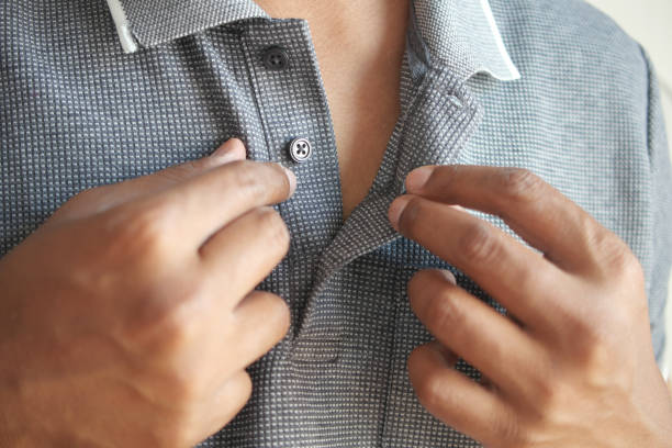 istock Man buttoning his shirt close up 1676623974
