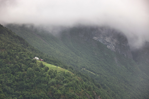 Lonely isolated house sitting high on a cliff in Geirangerfjorden in Norway