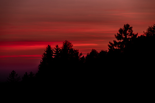 Dramatic red-orange blurred background of the setting sun. Abstract natural background