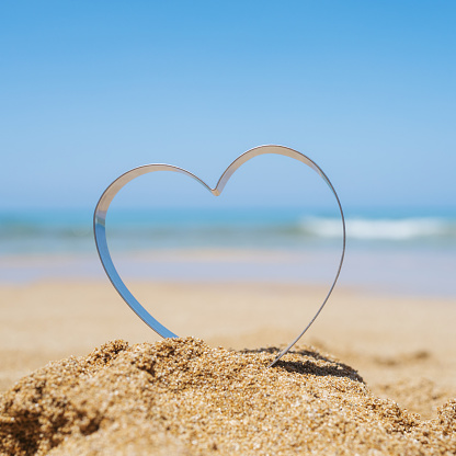 Sea view through shape of heart in the sand of tropical beach. Valentines day. Holiday, vacation concept. Creative, background, copy space, travel, summer.