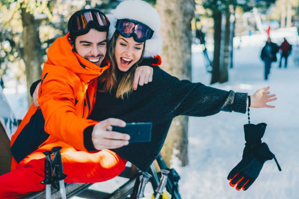 Couple on winter holiday taking selfie stock photo