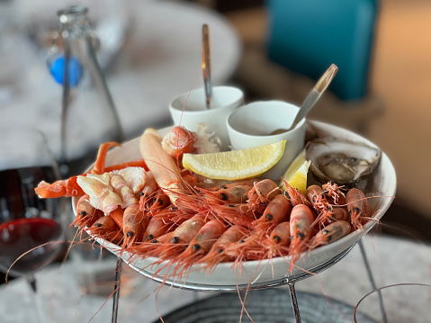 A serving platter of chilled seafood, including wild caught shrimp, Alaskan king crab legs, crab and oysters