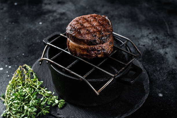 istock Fillet Mignon grilled beef Steak on a grill. Black background. Top view 1676643513