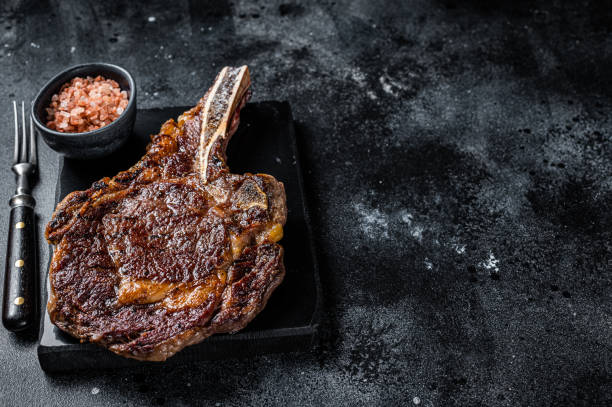 istock Grilled cowboy or rib eye with bone beef steak. Black background. Top view. Copy space 1676659759