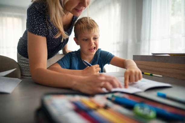 istock Mother helping cute little boy in doing homework 1676675102