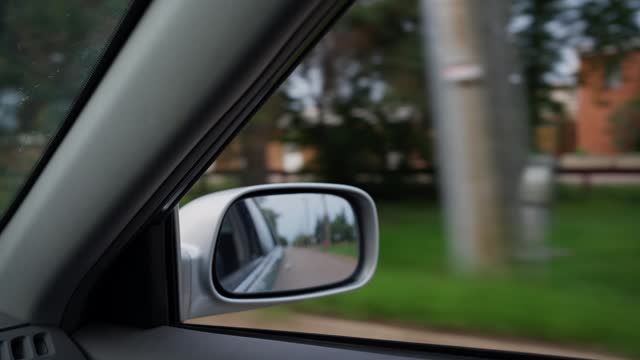 Reflection in the mirror of a car driving in the suburbs