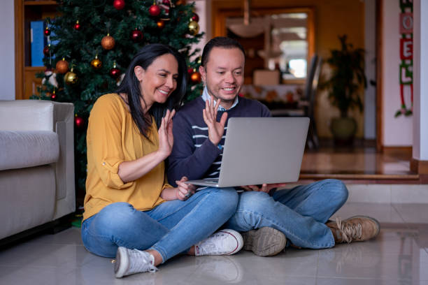 istock Latin American couple looking very cheerful while on a video call using a laptop during Christmas celebration 1676718181