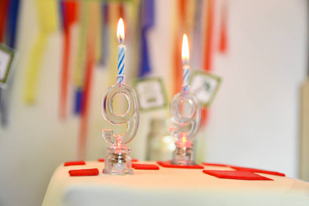 Birthday Candles and Party Decoration - Close-UP Birthday Candles and Party Decoration, it is a 9 year or 99 Year Candle lit on a Cake. prowling stock pictures, royalty-free photos & images