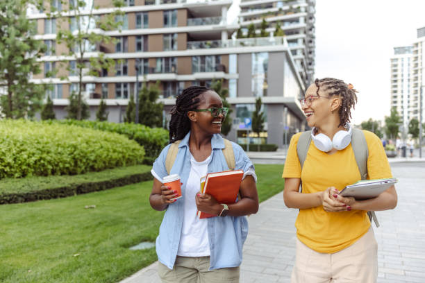istock Two young female college students having a cheerful discussion, while walking to class 1676822685