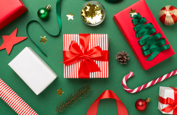 istock Gift boxes with paper's rools and christmas decoration on color background, top view 1676824976