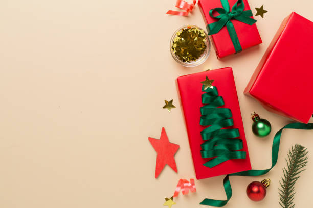 istock Gift boxes with paper's rools and christmas decoration on color background, top view 1676824989