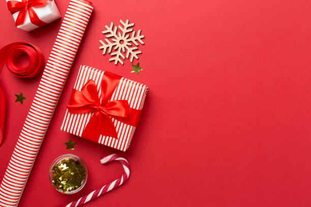 istock Gift boxes with paper's rools and christmas decoration on color background, top view 1676825488