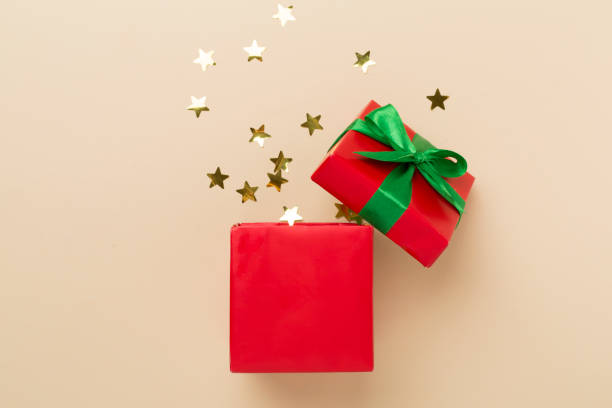 istock Open red gift box with party confetti on color background, top view 1676825500