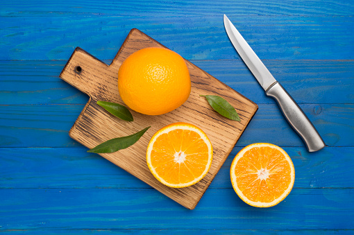 Fresh oranges with leaves on wooden background.