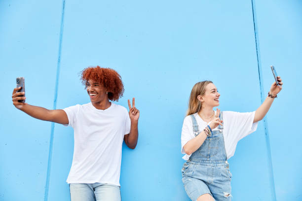 istock Friends taking selfie gesturing victory on a blue wall 1676849354